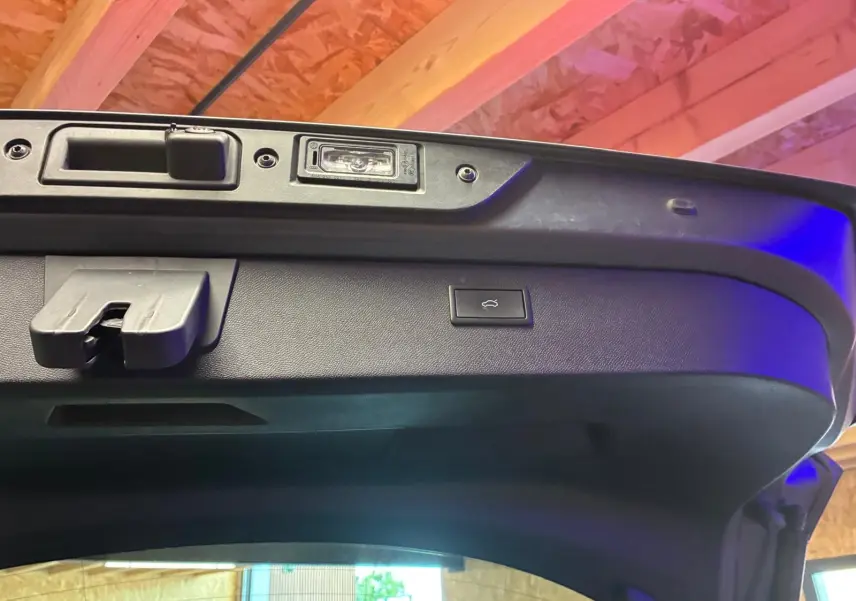 Détail intérieur du hayon ouvert d’une CUPRA Formentor gris foncé mat, montrant la commande d’ouverture électrique.