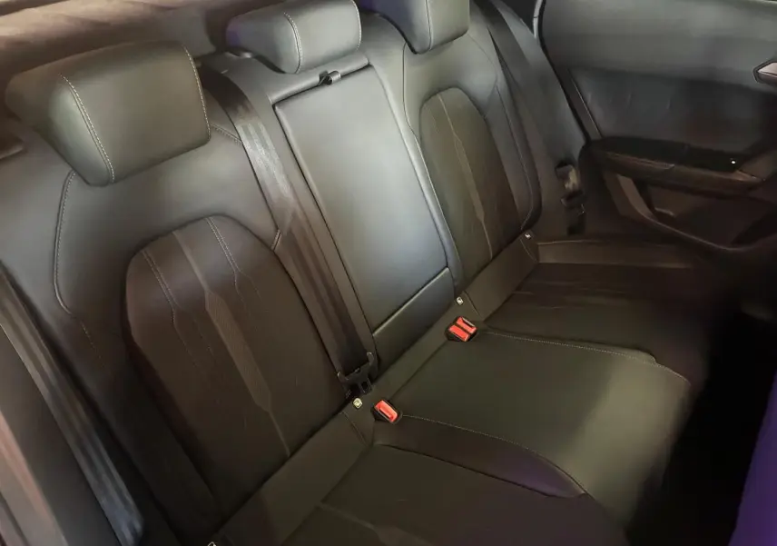 Vue intérieure arrière des sièges en cuir noir de la CUPRA Formentor 1.4 E-HYBRID 245 DSG6 VZ, avec ceintures et appuie-têtes.