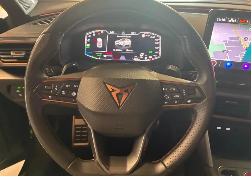 Vue rapprochée du volant en cuir noir perforé avec logo CUPRA cuivré et tableau de bord numérique du Formentor 1.4 hybride.