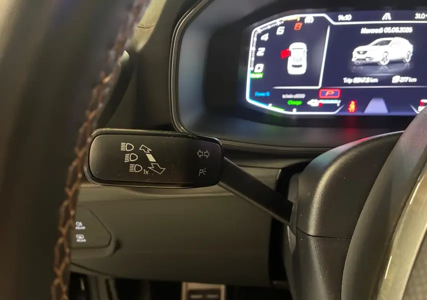 Gros plan sur le commodo gauche du volant du CUPRA Formentor gris foncé mat, avec tableau de bord numérique en arrière-plan.