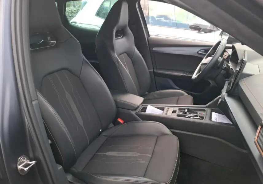 Vue arrière d'une CUPRA Formentor 1.4 E-HYBRID 245 DSG6 VZ gris foncé mat avec feux arrière LED allumés en intérieur.
