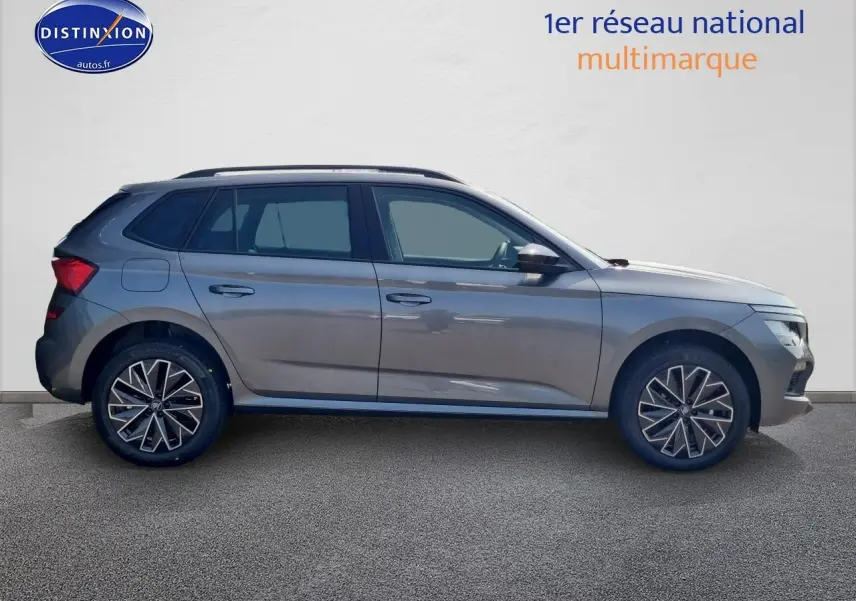 Profil côté gauche d'un Skoda Kamiq gris graphite 2025 avec barres de toit noires et jantes stylisées.