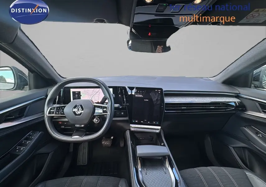 Vue intérieure avant du Renault Austral 2023 gris schiste, tableau de bord moderne avec écran tactile vertical et volant multifonction.