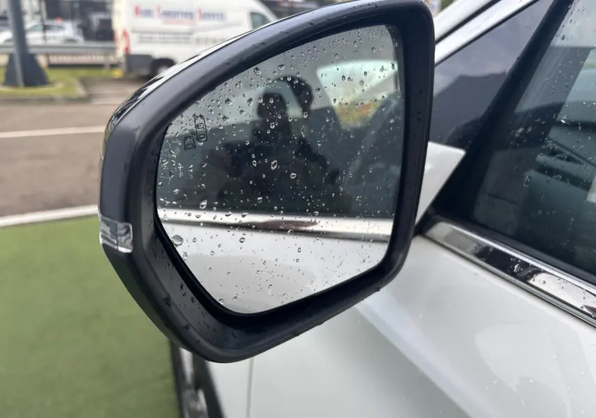 Rétroviseur extérieur côté gauche blanc nacré du DS7 Crossback 2021 avec gouttes de pluie visibles.