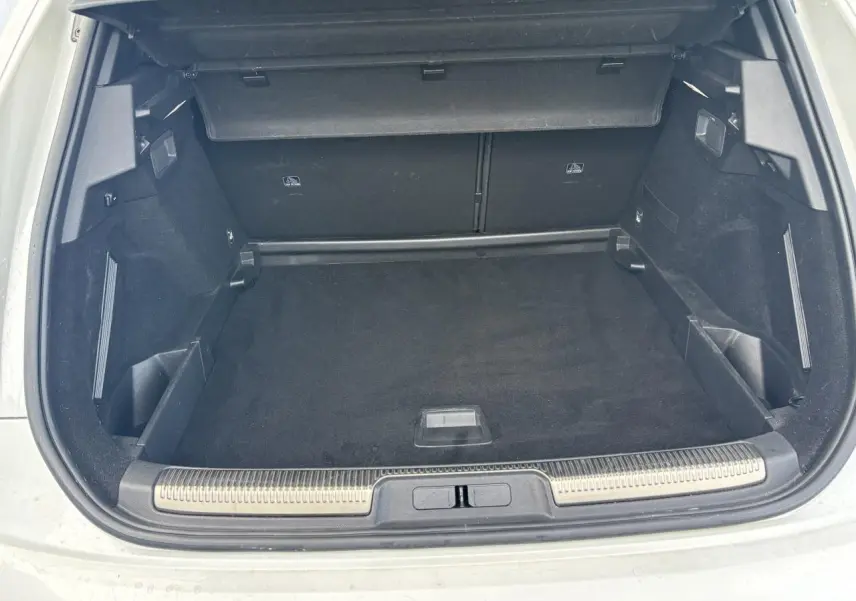 Coffre ouvert du DS7 Crossback blanc, vue arrière montrant un espace de chargement spacieux et bien fini.
