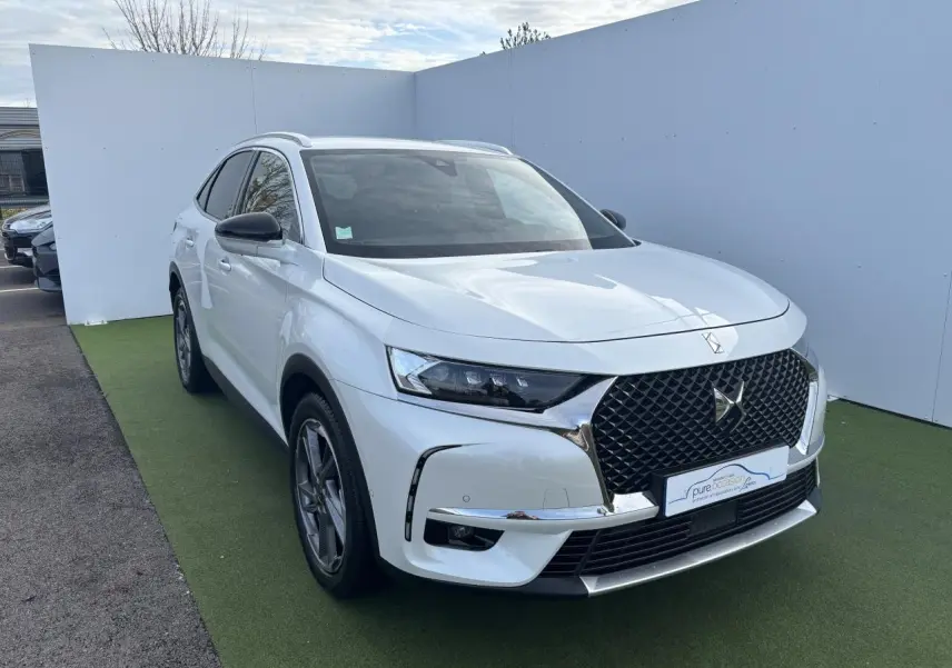DS7 Crossback blanc en vue 3/4 avant gauche avec calandre DS Wings chromée et phares LED distinctifs.