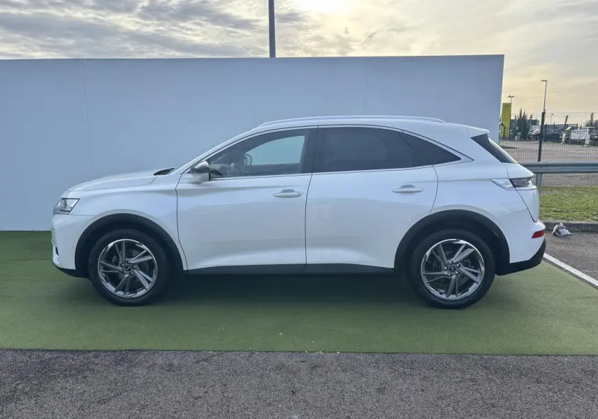 Profil côté gauche du SUV blanc DS7 Crossback 2021 avec vitres arrière surteintées et jantes alliage.