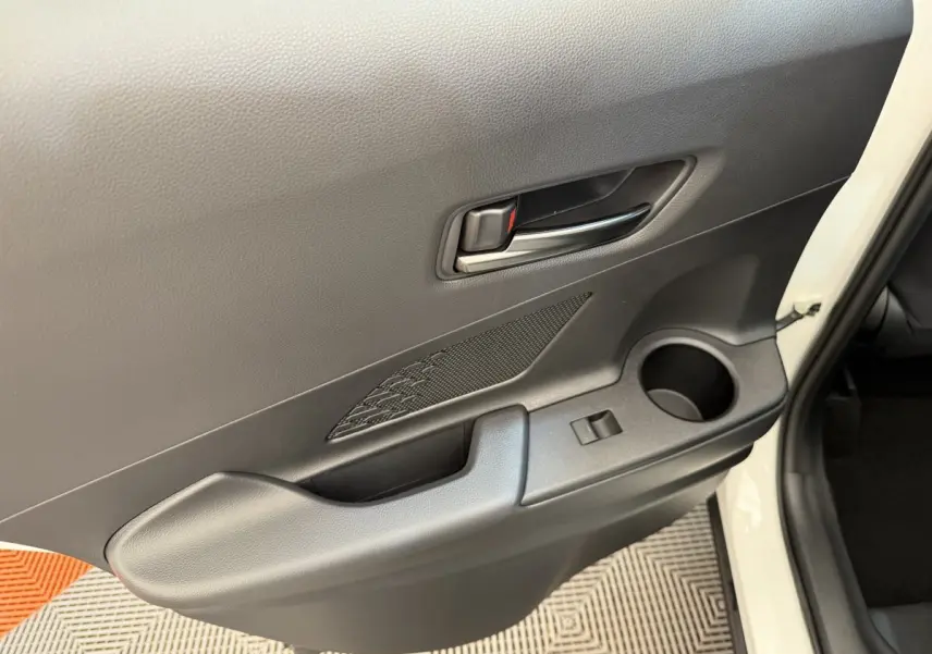 Gros plan sur la porte arrière droite blanche du Toyota C-HR 2024, avec poignée intérieure noire et rangement intégré.