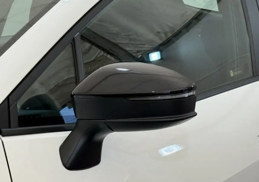 Rétroviseur noir côté gauche du Toyota C-HR blanc 2024, avec clignotant intégré visible sur la coque.