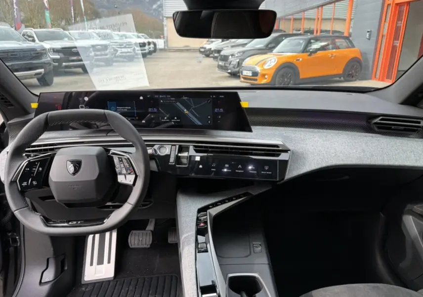 Vue intérieure frontale du Peugeot 3008 Hybrid 145 GT Alcantara, mettant en valeur le volant cuir multifonctions et l’écran digital panoramique.