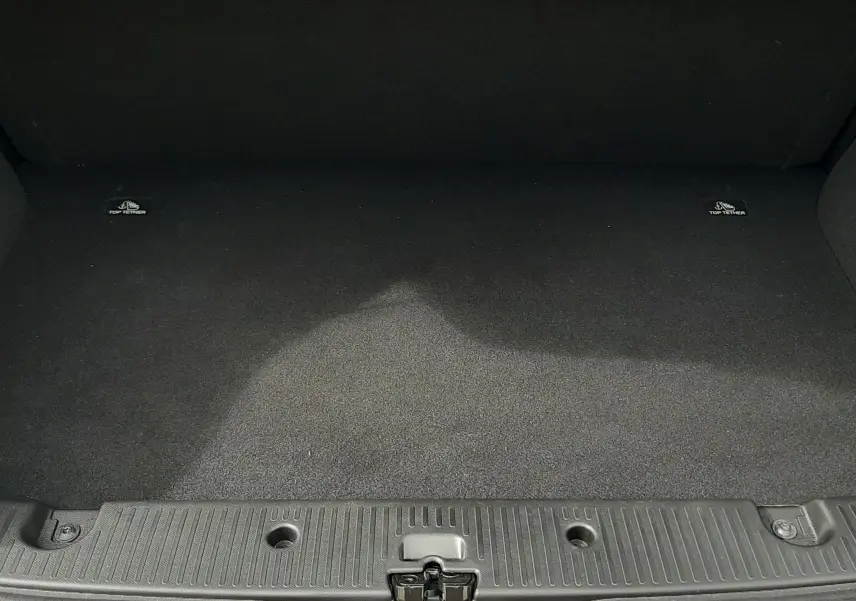 Coffre ouvert vu de face de la Renault Twingo III blanc cristal, montrant un espace de chargement propre et vide.