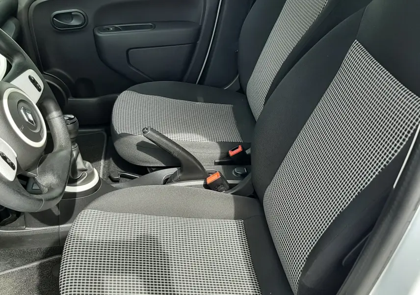 Vue intérieure côté gauche de la Renault Twingo III Life 2021, sièges tissu gris noir avec motifs à carreaux.