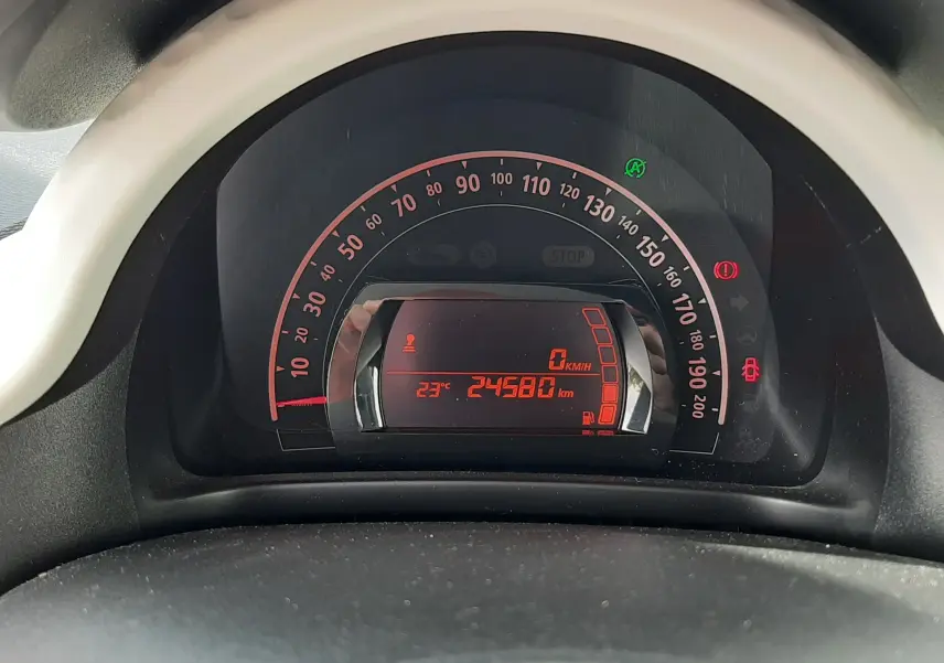 Vue rapprochée du tableau de bord numérique de la Renault Twingo III blanche, affichant 24 580 km et température 23°C.