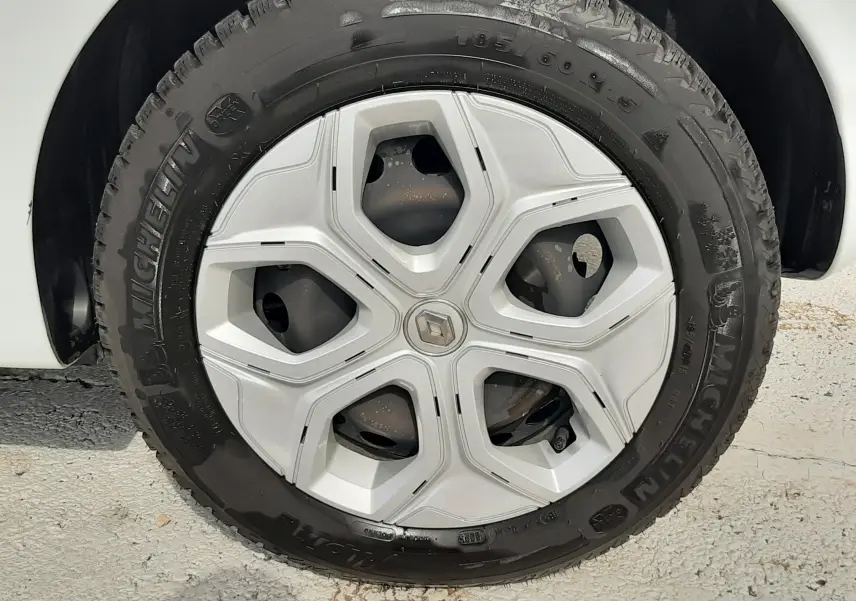 Gros plan sur la roue avant droite d'une Renault Twingo III blanche, mettant en valeur le pneu Michelin tout-terrain.