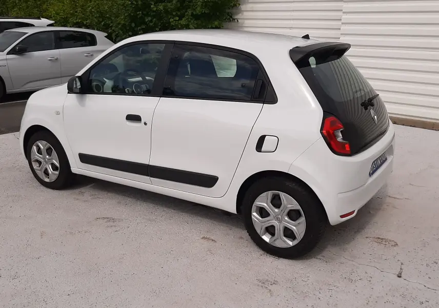 Renault Twingo III blanc cristal vue 3/4 arrière côté gauche, avec poignées noires et jantes originales.