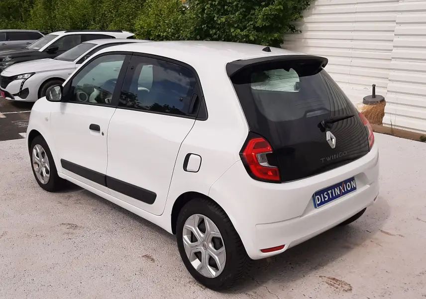 Vue 3/4 arrière droite d'une Renault Twingo III blanche cristal, avec vitres teintées et jantes alliage.