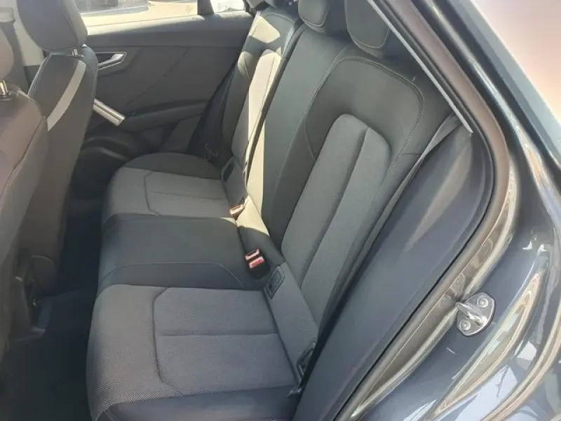 Vue intérieure côté droit sur la banquette arrière tissu noir et gris de l'Audi Q2 30 TDI 2025 gris Manhattan métallisé.