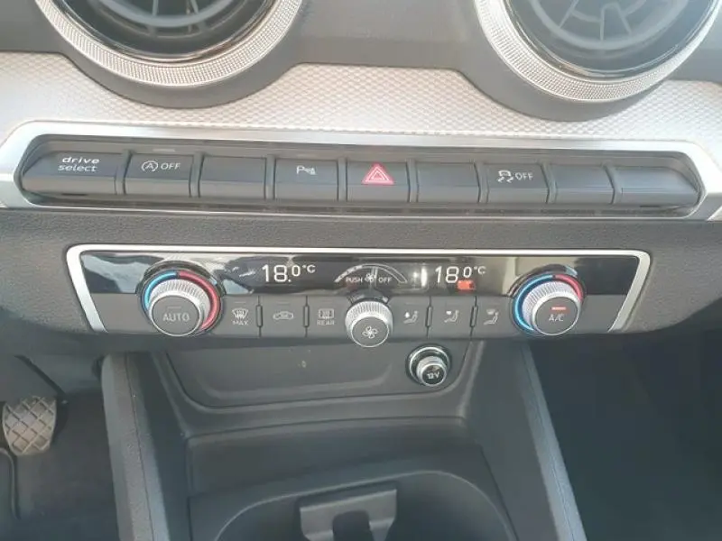 Détail du tableau de bord de l'Audi Q2 30 TDI 116ch Design 2025 montrant la commande de climatisation automatique à 18°C.