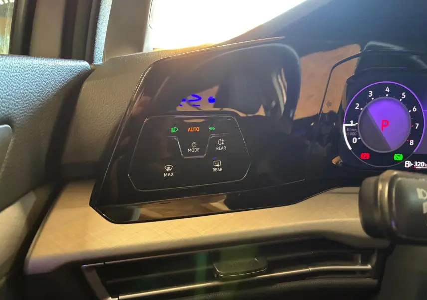 Vue rapprochée du tableau de bord de la Volkswagen Golf 2023, montrant les commandes d'éclairage et le compteur digital.