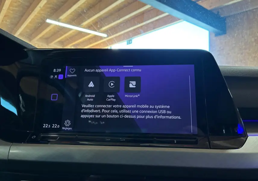 Vue rapprochée de l'écran tactile central du tableau de bord d'une Volkswagen Golf gris clair 2023, affichant les options App-Connect.