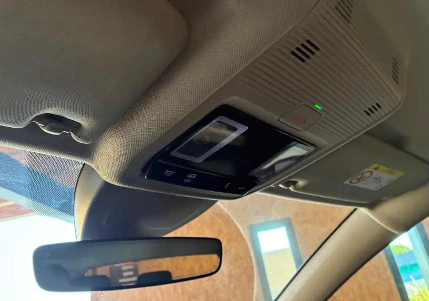 Détail du plafonnier beige avec commandes tactiles et rétroviseur intérieur d’une Volkswagen Golf gris clair 2023.