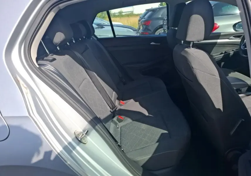 Vue intérieure côté gauche montrant les sièges arrière en tissu noir d'une Volkswagen Golf gris clair 2023.