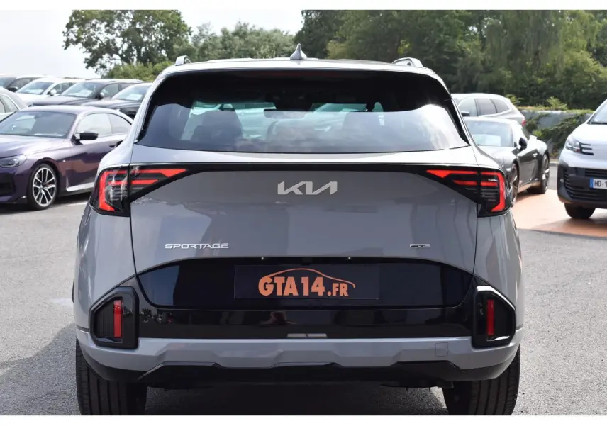 Vue arrière d'un Kia Sportage gris 2026 avec feux arrière LED et logo KIA visible sur le hayon.