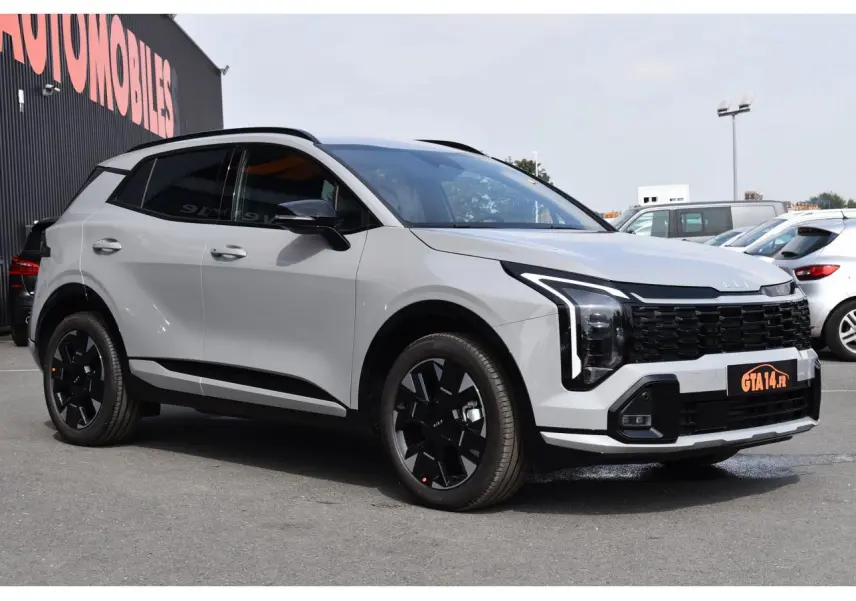 KIA SPORTAGE hybride gris en vue 3/4 avant droit avec jantes noires et calandre imposante.