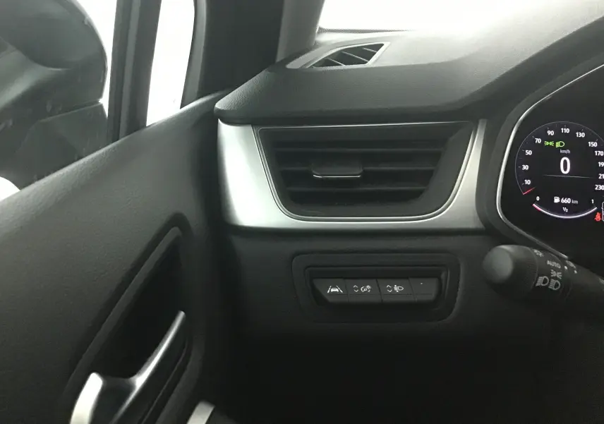 Détail du tableau de bord côté gauche du Renault Captur 2024 gris Cassiopée avec commandes d'assistance et compteur digital.