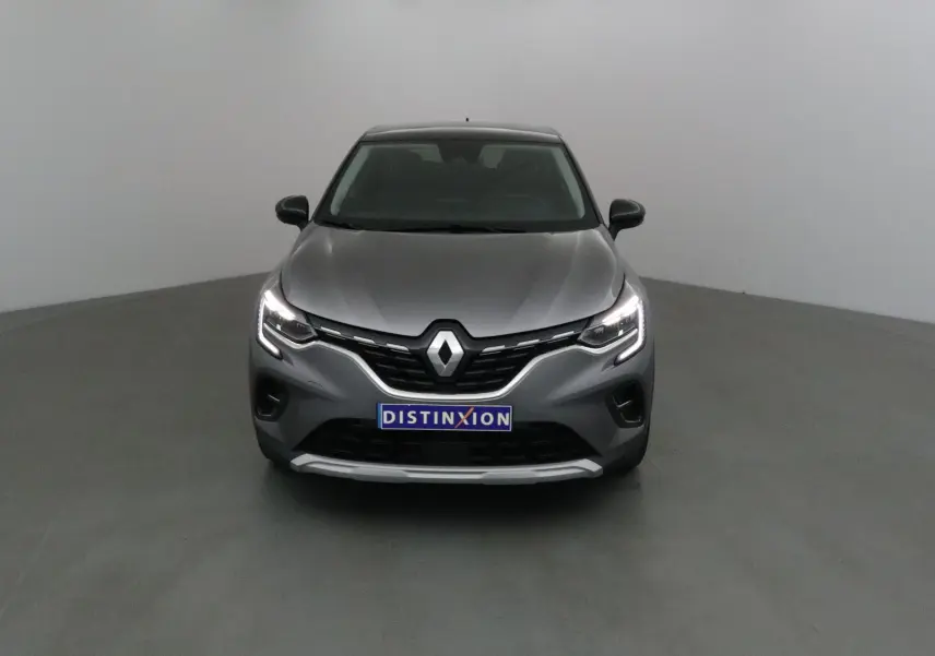 Vue frontale d'un Renault Captur gris Cassiopée avec calandre noire et feux LED allumés dans un studio.