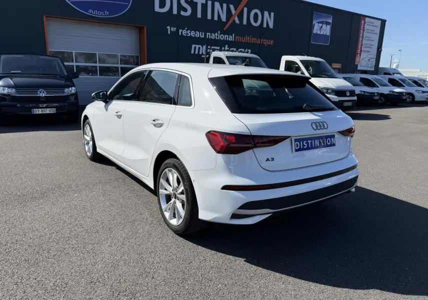 Audi A3 Sportback blanc Arcona vue 3/4 arrière droit, jantes alliage 5 branches et feux arrière LED visibles.