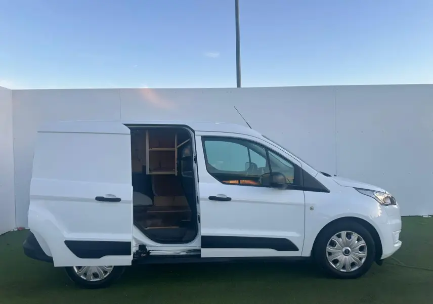 Vue latérale droite d'un Ford Transit Connect blanc 2019 avec porte coulissante ouverte et jantes acier.