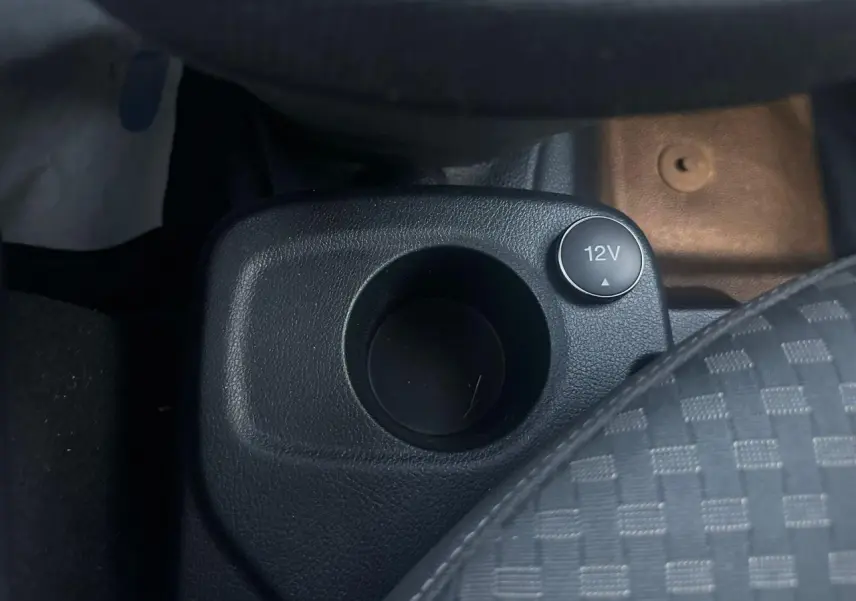 Gros plan sur la prise 12V et porte-gobelet noir dans l'habitacle du Ford Transit Connect blanc de 2019.