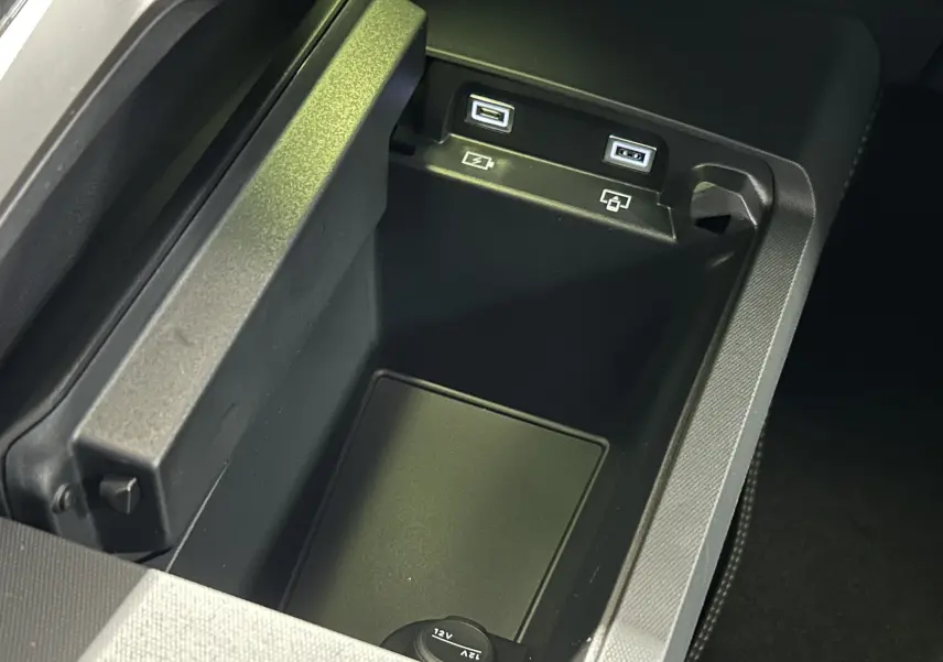 Vue rapprochée de la console centrale du Peugeot 3008 2025 gris Artense, montrant deux ports USB et une prise 12V.