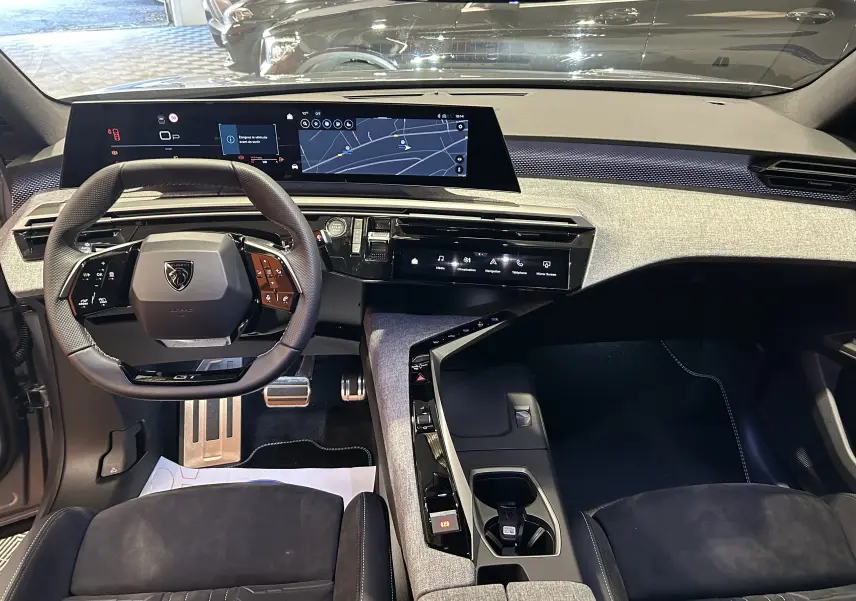 Vue intérieure avant du Peugeot 3008 III Hybrid gris Artense, tableau de bord moderne avec écran large et sellerie Alcantara noire.