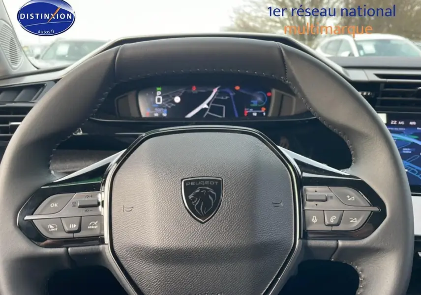 Vue rapprochée du volant noir multifonction de la Peugeot 308 1.2 hybrid 145 allure e-dcs6 avec tableau de bord numérique.