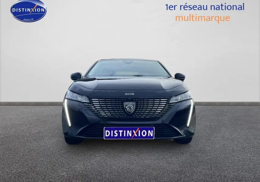 Vue avant d'une Peugeot 308 noire avec feux diurnes LED allumés sur fond neutre.