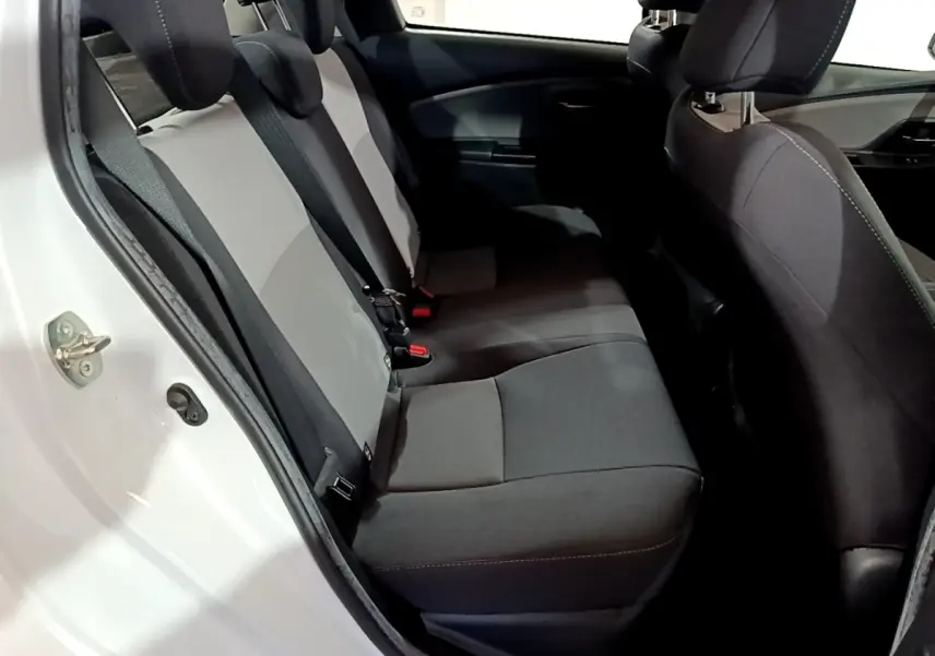 Vue intérieure côté gauche montrant la banquette arrière bicolore gris et noir de la Toyota Yaris 1.5 Hybride 2020 blanche.
