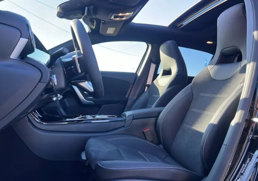 Intérieur noir de la Mercedes Classe A 200D BVA Exclusive Design vu côté conducteur, avec sièges sport et toit ouvrant panoramique.