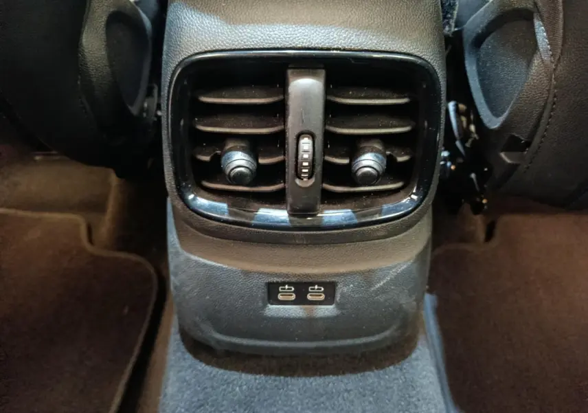 Vue rapprochée des bouches d’aération arrière et ports USB noirs du MINI Countryman gris foncé, intérieur au sol sombre.