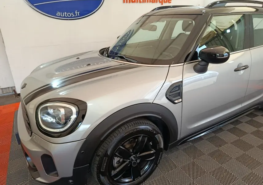Vue 3/4 avant droit d'une MINI Countryman gris foncé avec jantes noires et toit noir brillant.