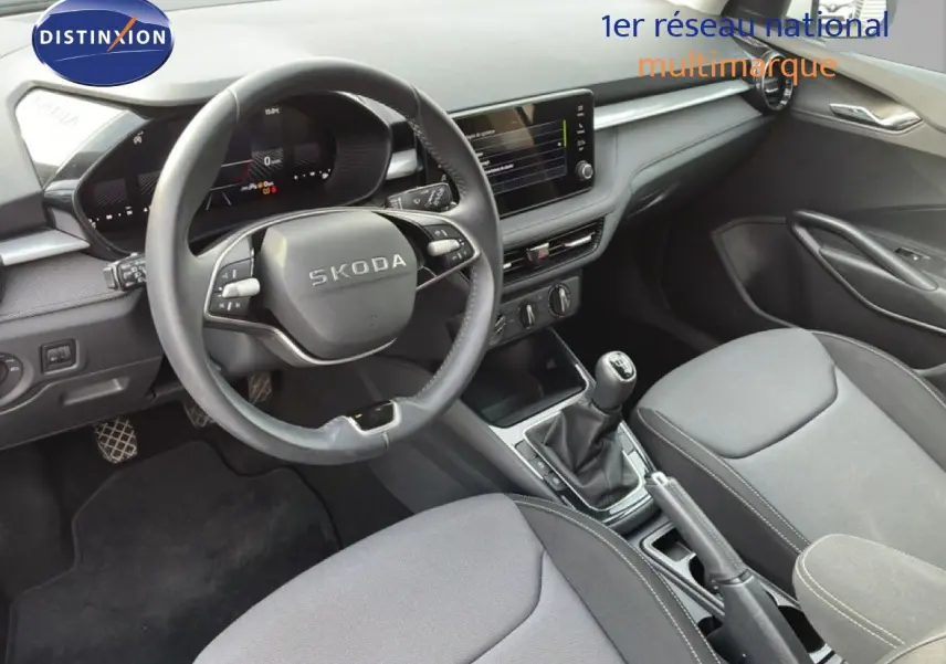 Vue intérieure côté conducteur de la Skoda Fabia 2025, tableau de bord moderne avec volant multifonction et écran tactile central.