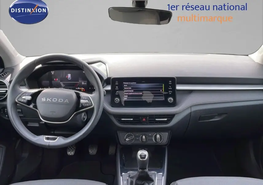 Vue frontale de l’habitacle de la Skoda Fabia 2025 avec tableau de bord moderne et écran tactile central.