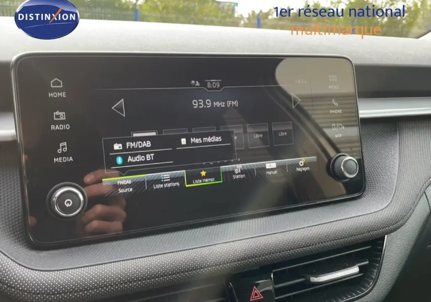 Écran tactile central du tableau de bord de la Skoda Fabia blanc glacier 2025, affichant la radio FM/DAB.
