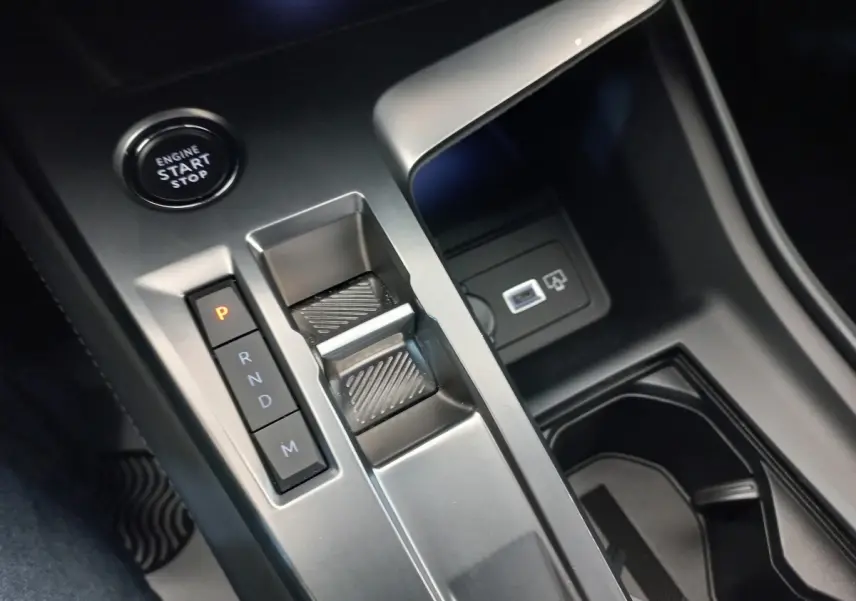 Gros plan sur la console centrale de la Peugeot 308 bleu, montrant la commande de boîte auto et le bouton start/stop.