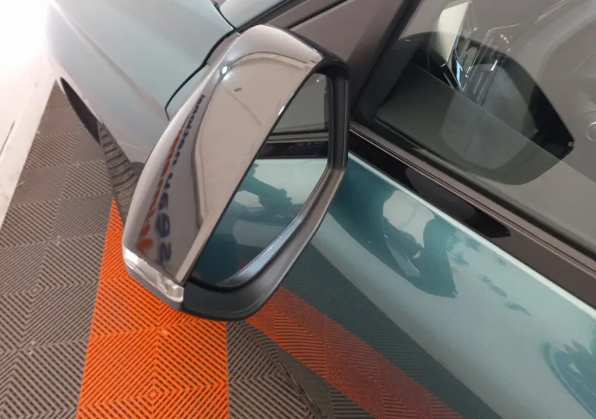 Rétroviseur droit rabattable électriquement sur Peugeot 308 bleu, vue rapprochée côté conducteur.