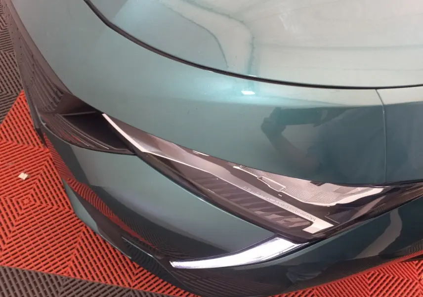 Gros plan sur le phare avant gauche bleu métallisé de la Peugeot 308 PureTech 130 avec détails LED et design anguleux.