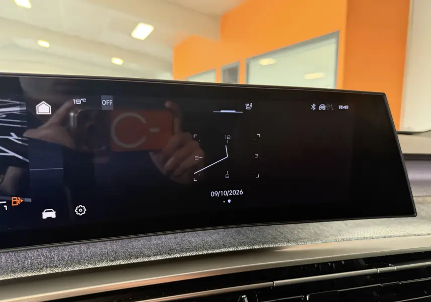 Écran tactile intérieur du tableau de bord du Peugeot 3008 Hybrid 145 GT, affichant une horloge digitale.
