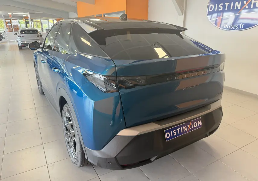 Vue 3/4 arrière droite du Peugeot 3008 Hybrid 145 GT bleu Obsession avec toit noir et jantes alliage 19 pouces en showroom.