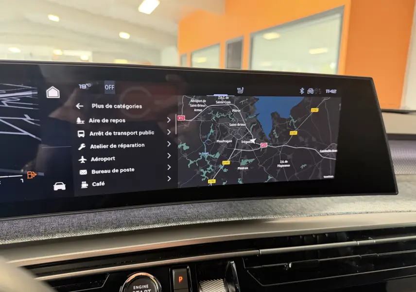 Intérieur du Peugeot 3008 Hybrid 145 GT, affichage GPS large sur tableau de bord moderne avec finition tissu visible.